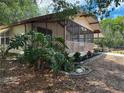 Charming single-story home with a large screened porch and mature landscaping at 11407 Bobwhite Blvd, Leesburg, FL 34788