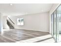 Spacious living room features stairs with dark railings, hardwood floors, and a sliding glass door at 1403 Hamilton Way, Lake Alfred, FL 33850