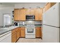 Bright kitchen featuring white appliances, wooden cabinets, and ample counter space at 30653 Pga Dr, Sorrento, FL 32776