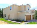 Well-maintained two-story home with lush landscaping, side door, and two-car garage at 575 Bay Leaf Dr, Poinciana, FL 34759