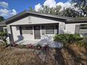 Charming single-story home with a gray exterior, a well-maintained front yard, and landscaping at 917 Adamson Ct, Lake Alfred, FL 33850