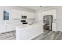 Kitchen with stainless steel appliances, white cabinets, granite countertops, and tile backsplash at 1411 Hamilton Way, Lake Alfred, FL 33850
