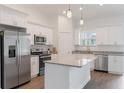 Bright kitchen features stainless steel appliances, white cabinetry, granite countertops, and modern pendant lighting at 14404 Sw 19Th Pl, Ocala, FL 34481