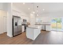 Bright kitchen boasts stainless steel appliances, granite countertops, a center island, and sliding door access at 14404 Sw 19Th Pl, Ocala, FL 34481