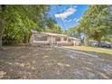A single-story home with a well-maintained lawn and mature trees in a residential neighborhood at 406 W Valencia St, Lakeland, FL 33805