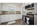 A bright kitchen featuring white cabinets, granite countertops, stainless steel appliances and stylish backsplash at 406 W Valencia St, Lakeland, FL 33805