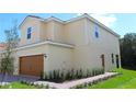 Tan two-story home boasting a two-car garage and a well-manicured lawn at 587 Bay Leaf Dr, Poinciana, FL 34759
