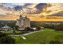 Breathtaking aerial view of a high-rise building and sprawling golf course at sunset at 7673 Heritage Crossing Way # 202, Reunion, FL 34747