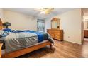 Cozy bedroom with hardwood floors, ceiling fan, a large bed, and wood dresser at 2138 Mirasol Dr, Winter Haven, FL 33881