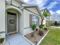 Inviting front entrance with a decorative wreath, manicured landscaping, and a charming stone border enhancing the home's curb appeal at 3205 Royal Tern Dr, Winter Haven, FL 33881