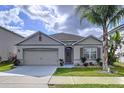 Charming single-story home with a two-car garage, lovely landscaping, and a welcoming front entrance with beautiful flowers at 3205 Royal Tern Dr, Winter Haven, FL 33881