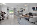 Open-concept living area with modern gray decor, tile flooring, and a seamless flow to the kitchen at 3360 Cross Fox Dr, Mulberry, FL 33860