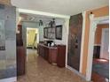 A kitchen area with dark cabinets, granite countertops, and tile flooring at 11305 Sw 186Th Cir, Dunnellon, FL 34432