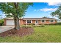 Inviting brick home with a lush green lawn and tidy landscaping enhances its curb appeal at 424 Forest Glen Ave, Lakeland, FL 33813