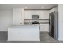 Modern kitchen featuring white cabinets, stainless steel appliances, and granite countertops at 113 Cimarron Ln, Poinciana, FL 34759