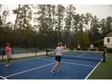 People are playing pickleball on an outdoor court with a net at 16958 Cedar Valley Cir, Clermont, FL 34711