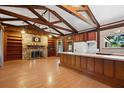 Open-concept living room featuring exposed beams, a stone fireplace, and a breakfast bar at 1836 Cr 609B, Bushnell, FL 33513