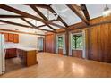 Spacious living room featuring wood walls, wood flooring, exposed beams, and natural light at 1836 Cr 609B, Bushnell, FL 33513