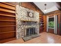 Cozy living room featuring a stone fireplace, built-in bookshelves, and wood flooring at 1836 Cr 609B, Bushnell, FL 33513