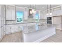 Bright kitchen featuring white cabinets, granite countertops, stainless steel appliances, and stylish pendant lighting at 23 Marden Dr # 51, Ormond Beach, FL 32176