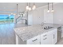 Open-concept kitchen with granite island, stainless steel sink, and views of the living area and ocean beyond at 23 Marden Dr # 51, Ormond Beach, FL 32176