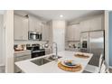 Modern kitchen featuring stainless steel appliances, light gray cabinets, white countertops, and an island with a stainless steel sink at 622 Terrapin Dr, Debary, FL 32713