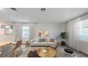 Bright living room featuring modern decor, stylish coffee tables, neutral furniture, and window with natural light at 732 Honeyrock St, Debary, FL 32713