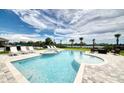 Relaxing backyard oasis with a sparkling pool, spa, lounge chairs, and lush landscaping at 7682 Fairfax Dr, Kissimmee, FL 34747