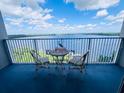 Balcony view with table and chairs overlooking the water at 13415 Blue Heron Beach Dr # 1006, Orlando, FL 32821