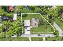 Aerial view showcasing the home's layout, including the main house, detached garage, and surrounding greenery at 7165 Cr 655, Bushnell, FL 33513