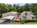 View of the home showcasing the house, detached garage and carport, surrounded by well maintained yard at 7165 Cr 655, Bushnell, FL 33513