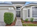 A welcoming front entrance with a charming wreath, tasteful landscaping and walkway leading to the front door at 2719 Osprey Creek Ln, Orlando, FL 32825