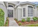 Close up of a welcoming front entrance with a charming wreath, tasteful landscaping and walkway leading to the front door at 2719 Osprey Creek Ln, Orlando, FL 32825