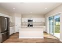 Bright kitchen featuring stainless steel appliances, a center island, and sliding glass doors at 1752 Frogmore Ave, Haines City, FL 33844