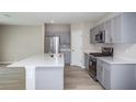 A kitchen with gray cabinets, stainless appliances and a quartz countertop at 1756 Frogmore Ave, Haines City, FL 33844