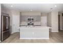A large kitchen with stainless steel appliances, a quartz island and light gray cabinets at 1756 Frogmore Ave, Haines City, FL 33844
