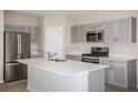 Modern kitchen featuring stainless steel appliances, gray cabinets, and quartz countertops at 1756 Frogmore Ave, Haines City, FL 33844