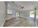 Open-concept living room featuring wood-look floors, ceiling fan and sliding glass doors to the outside at 210 Alta Vista St, Debary, FL 32713