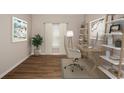Bright office space featuring a sleek wooden desk, stylish chair, and ample natural light from a large window at 1046 Foreshore Ln, Haines City, FL 33844