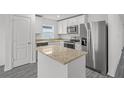 Modern kitchen features stainless steel appliances, granite countertops, and white cabinets at 431 Caribbean Ct, Poinciana, FL 34759