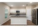 Well-lit kitchen with white cabinets, stainless steel appliances, and an island at 1042 Foreshore Ln, Haines City, FL 33844