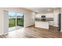 Bright kitchen featuring white cabinets, stainless steel appliances, an island, and a sliding door to the backyard at 1042 Foreshore Ln, Haines City, FL 33844