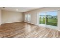 Open-plan living room with hardwood floors and a sliding glass door to the outside at 1042 Foreshore Ln, Haines City, FL 33844
