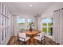 Cozy dining area with a round wood table, comfortable seating, and sliding glass doors at 1054 Foreshore Ln, Haines City, FL 33844
