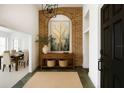 Inviting entryway features brick archway, decor, console table, and dark trim door at 1507 Wheeler Rd, Apopka, FL 32703