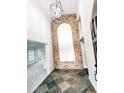 Bright foyer features brick accent wall, slate floors, and a modern light fixture at 1507 Wheeler Rd, Apopka, FL 32703