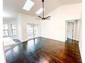 Open living room with hardwood floors, skylights, and access to the backyard at 1507 Wheeler Rd, Apopka, FL 32703