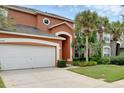 Inviting two-story home with a two-car garage, mature palm trees and a walkway at 8646 La Isla Dr, Kissimmee, FL 34747