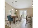 Dining room with modern table set, bar stool seating, and sliding glass doors to the backyard at 1 Pecan Course Cir, Ocala, FL 34472