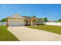 A home's exterior showcasing a well-maintained lawn, driveway, and a two-car garage at 1 Pecan Course Cir, Ocala, FL 34472